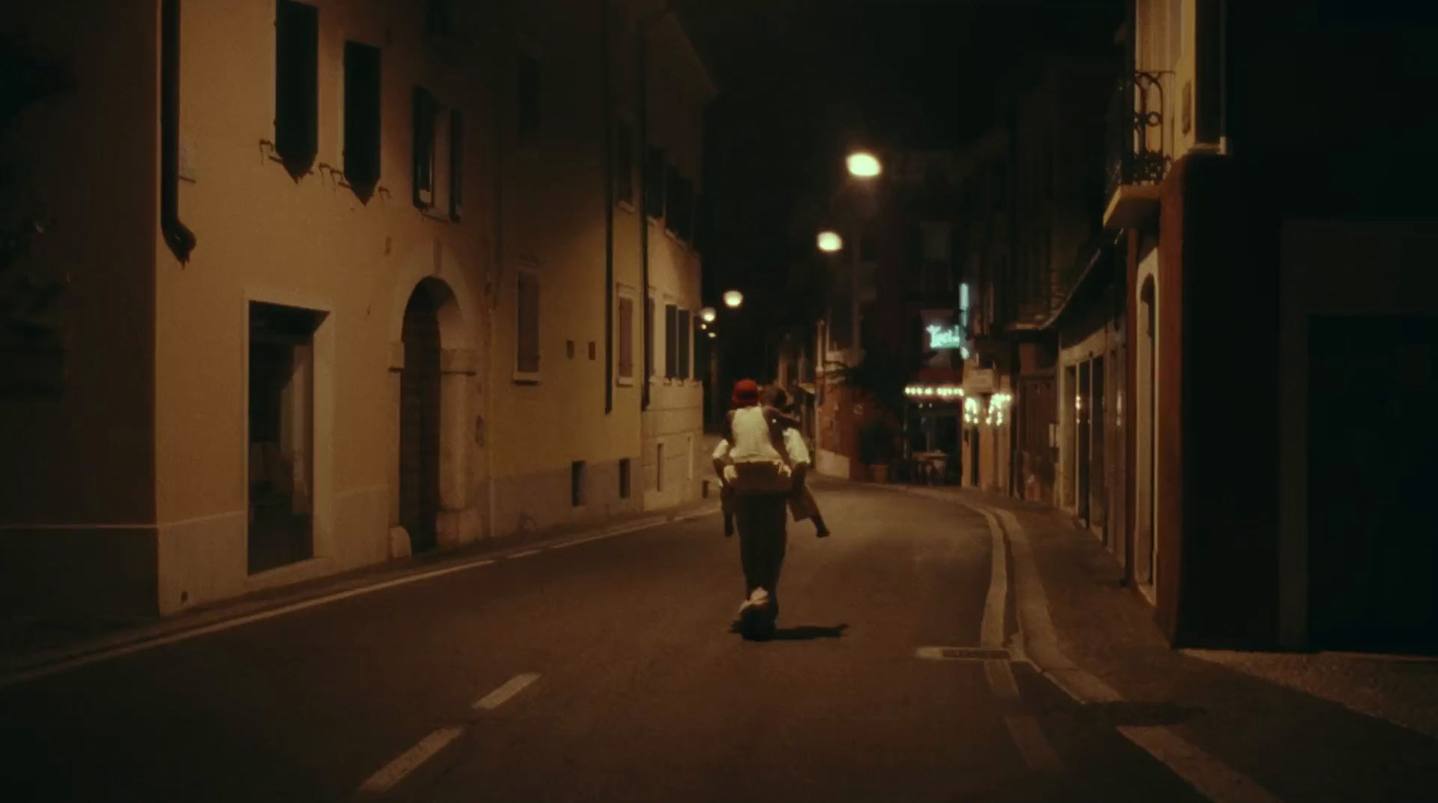 a man walking down a street at night