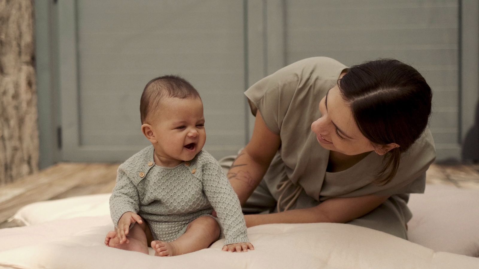 a woman is holding a baby on a bed