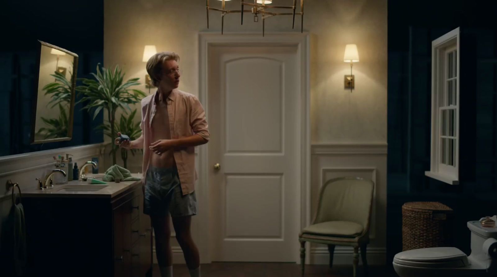 a man standing in a bathroom next to a sink