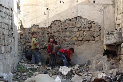 a group of young boys standing next to a pile of rubble