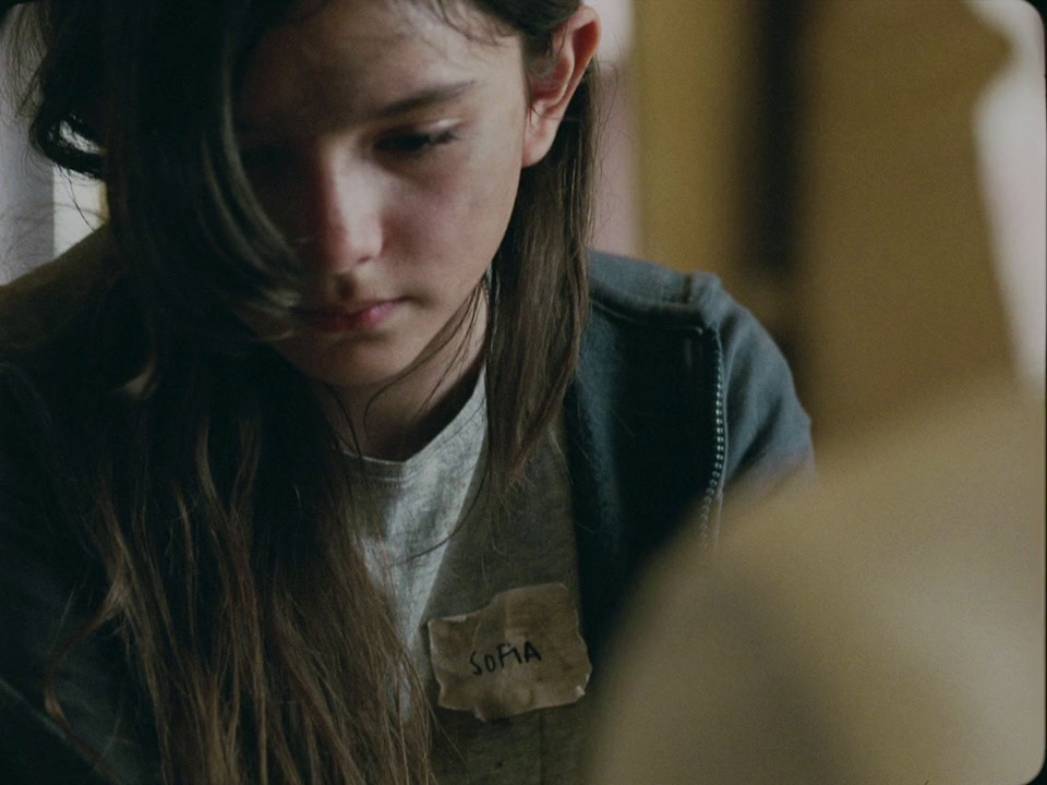 a girl with long hair looking down at her cell phone