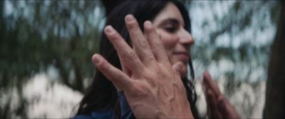 a woman holding her hand up to her face