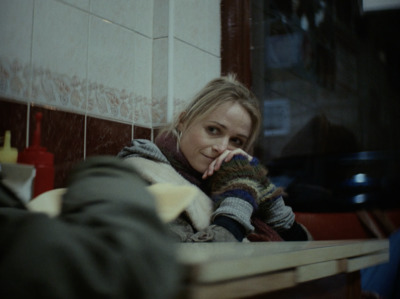 a woman sitting at a table with her hand on her face