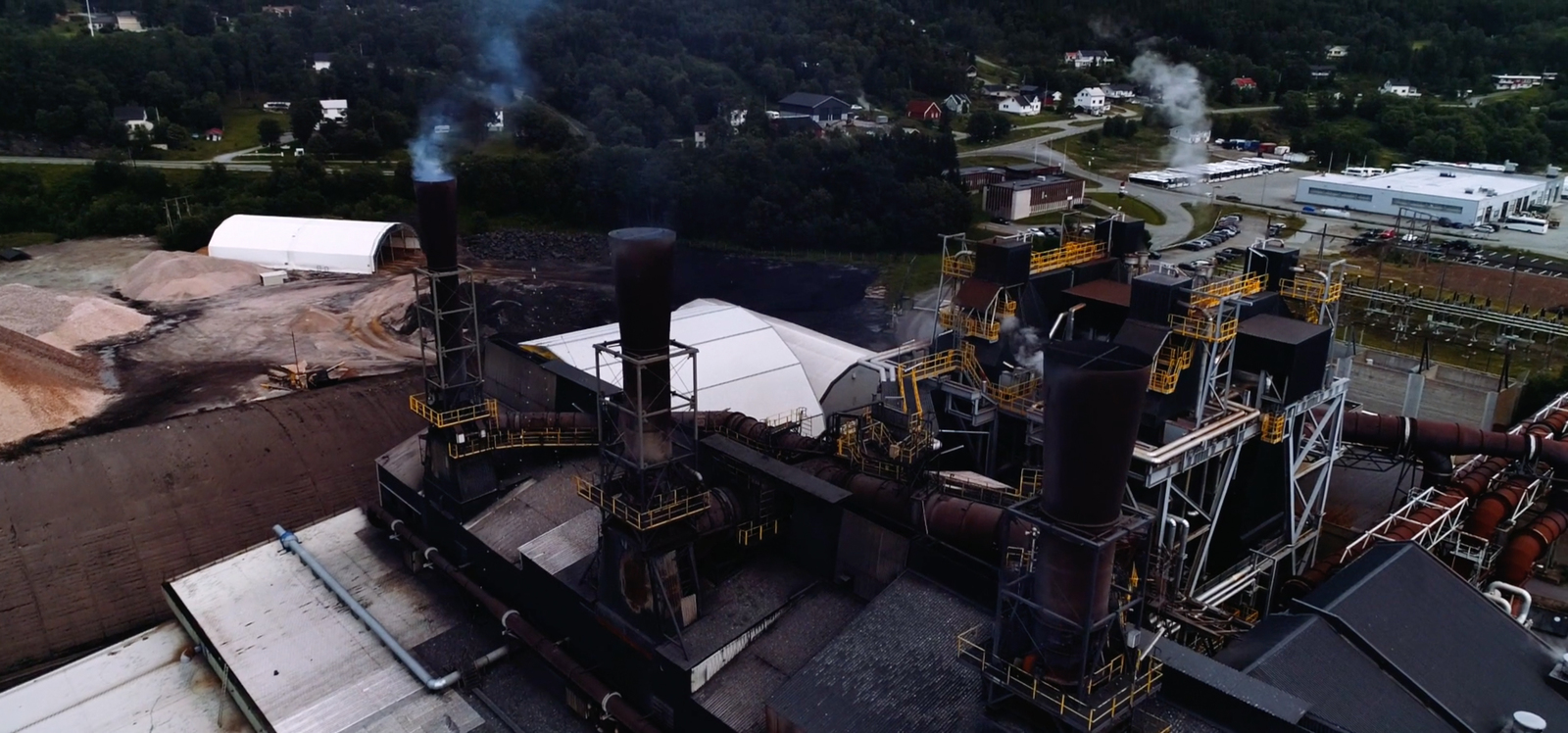 a factory with smoke coming out of the stacks