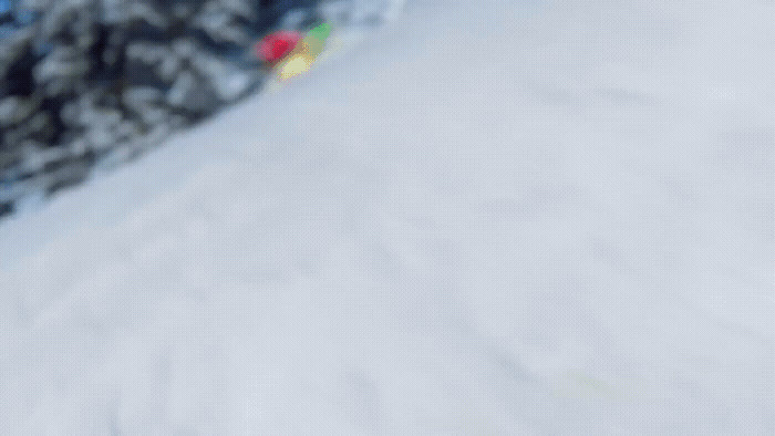 a person riding a snowboard down a snow covered slope