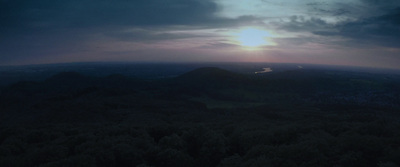 the sun is setting over the mountains in the distance