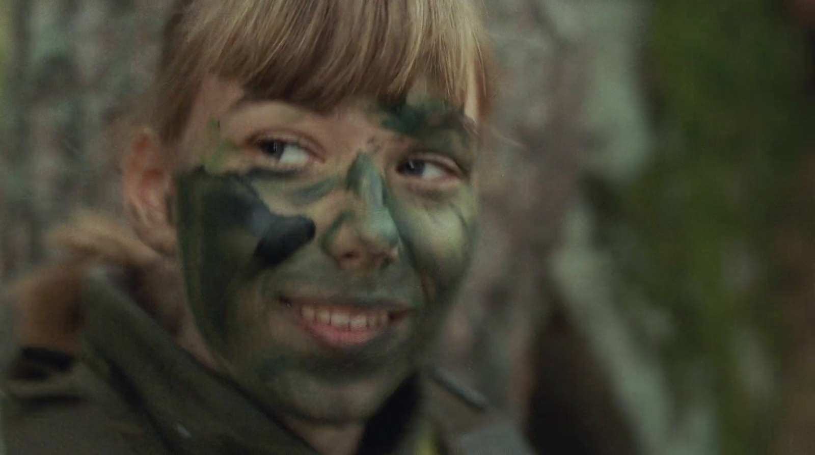 a man with a face painted with camouflage