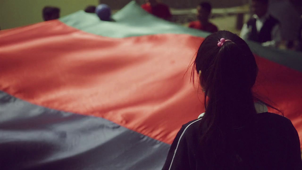 a girl standing in front of a large red and blue flag