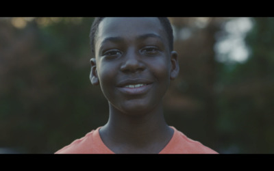 a close up of a person wearing an orange shirt