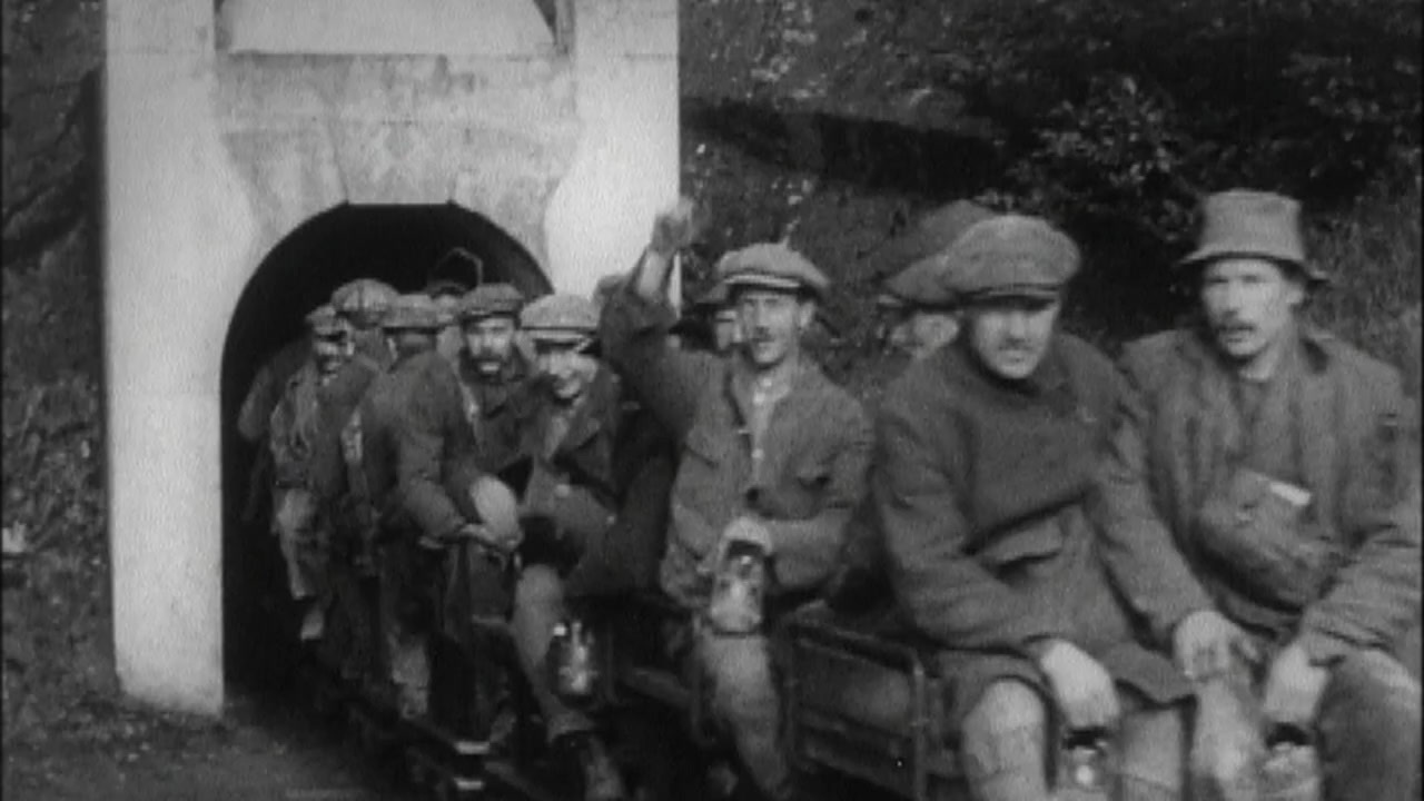 a group of men sitting next to each other in front of a tunnel