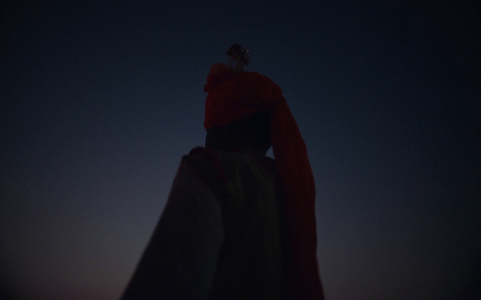 a woman in a red dress standing in the dark