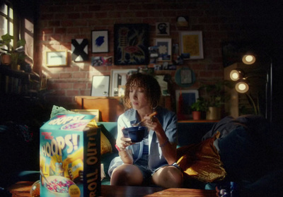 a young boy sitting on a couch eating cereal