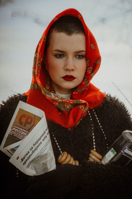 a woman in a red hoodie holding a cell phone