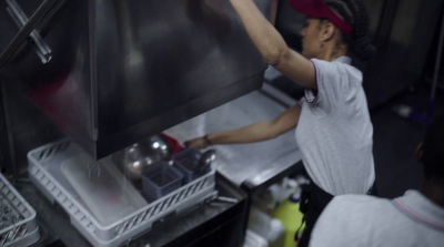 a woman in a white shirt and a red hat and some pots and pans