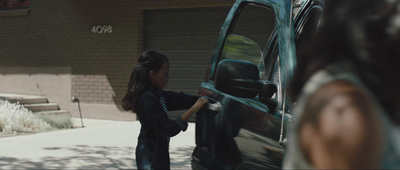 a little girl opening the door of a green van