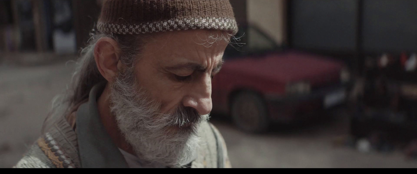 a man with a white beard wearing a brown hat