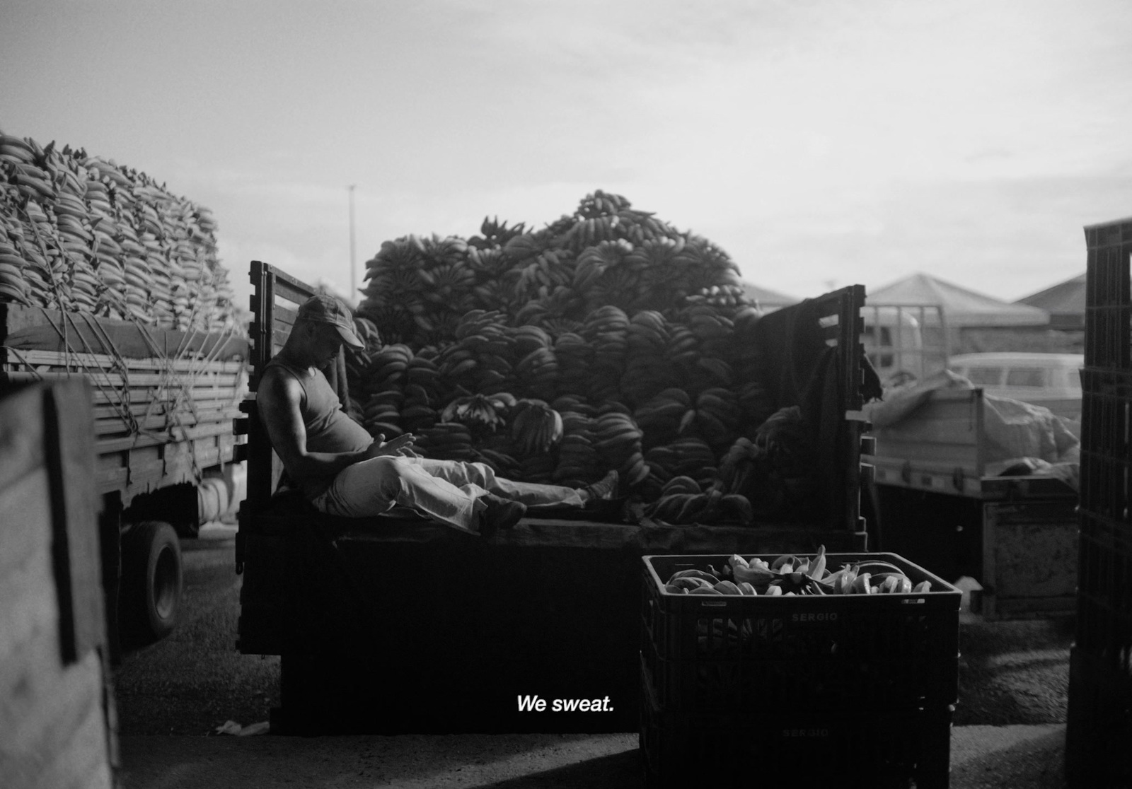 a black and white photo of a woman laying on a bed of bananas