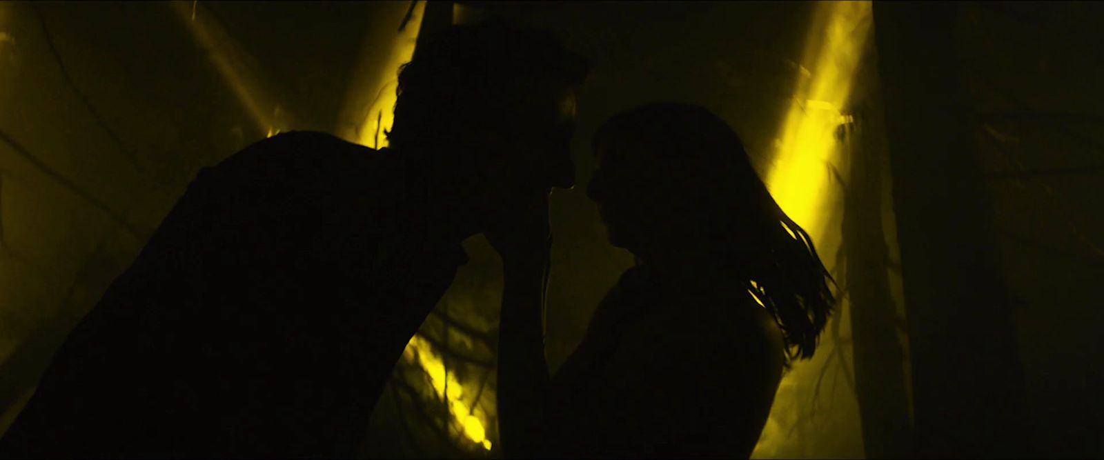 a man and a woman standing next to each other in a dark room