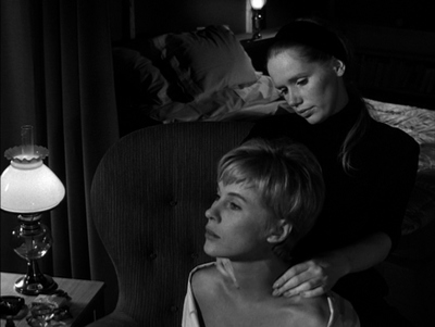 a black and white photo of two women sitting on a couch