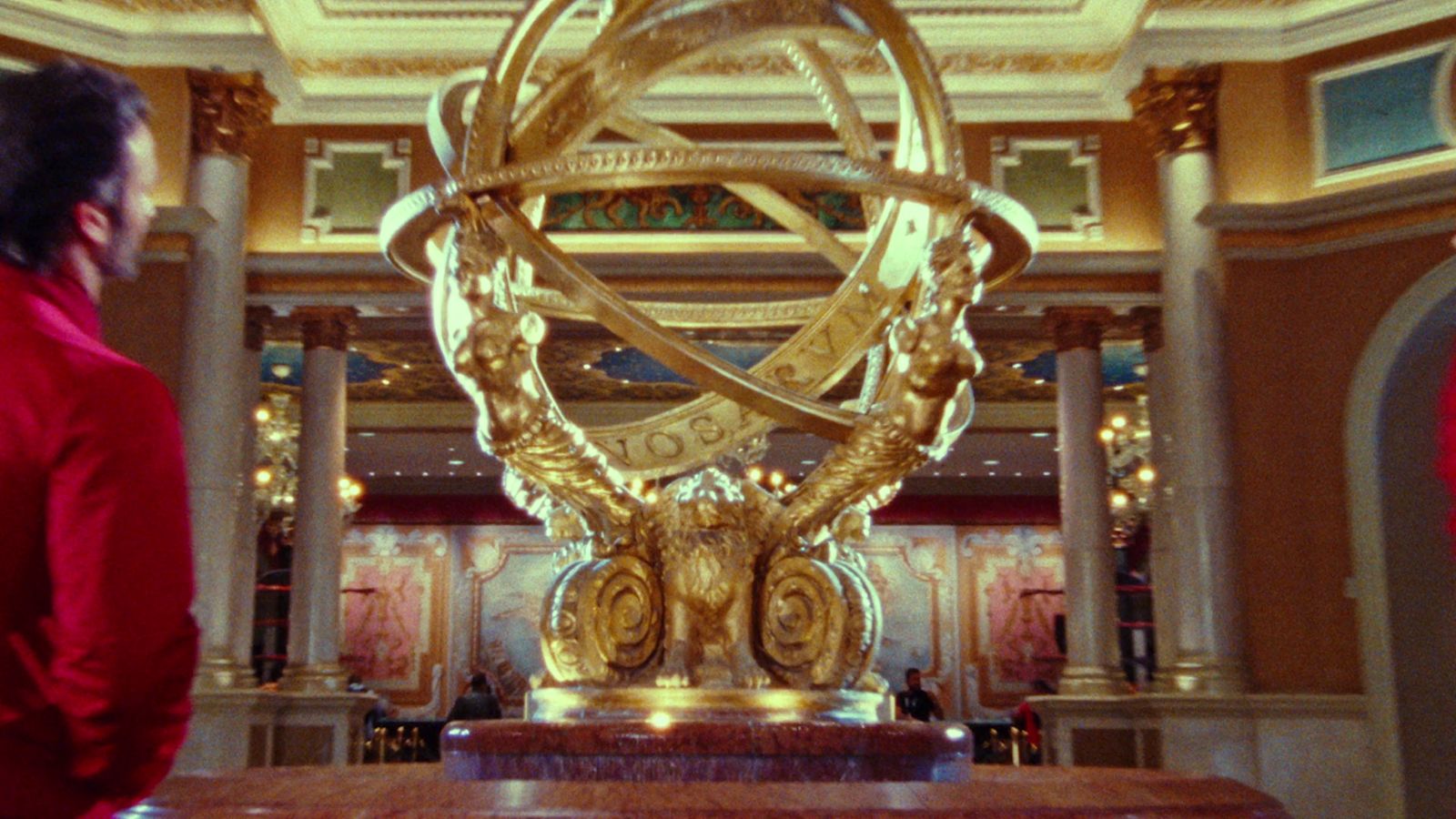 a man standing in front of a golden sculpture