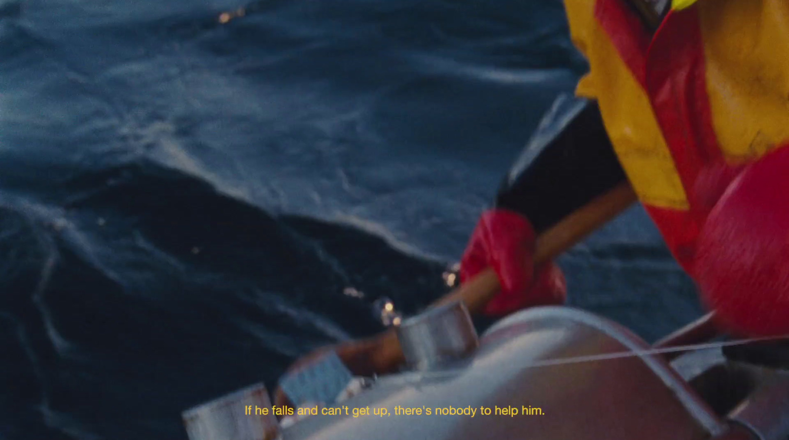 a man in a yellow and red life jacket on a boat