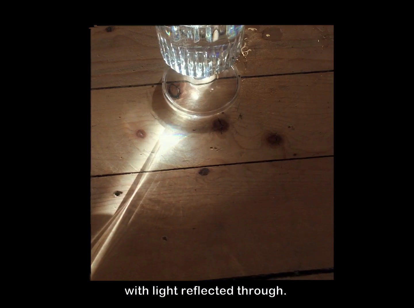 a glass of water sitting on top of a wooden table