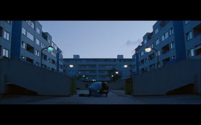 a person sitting on the ground in front of a building