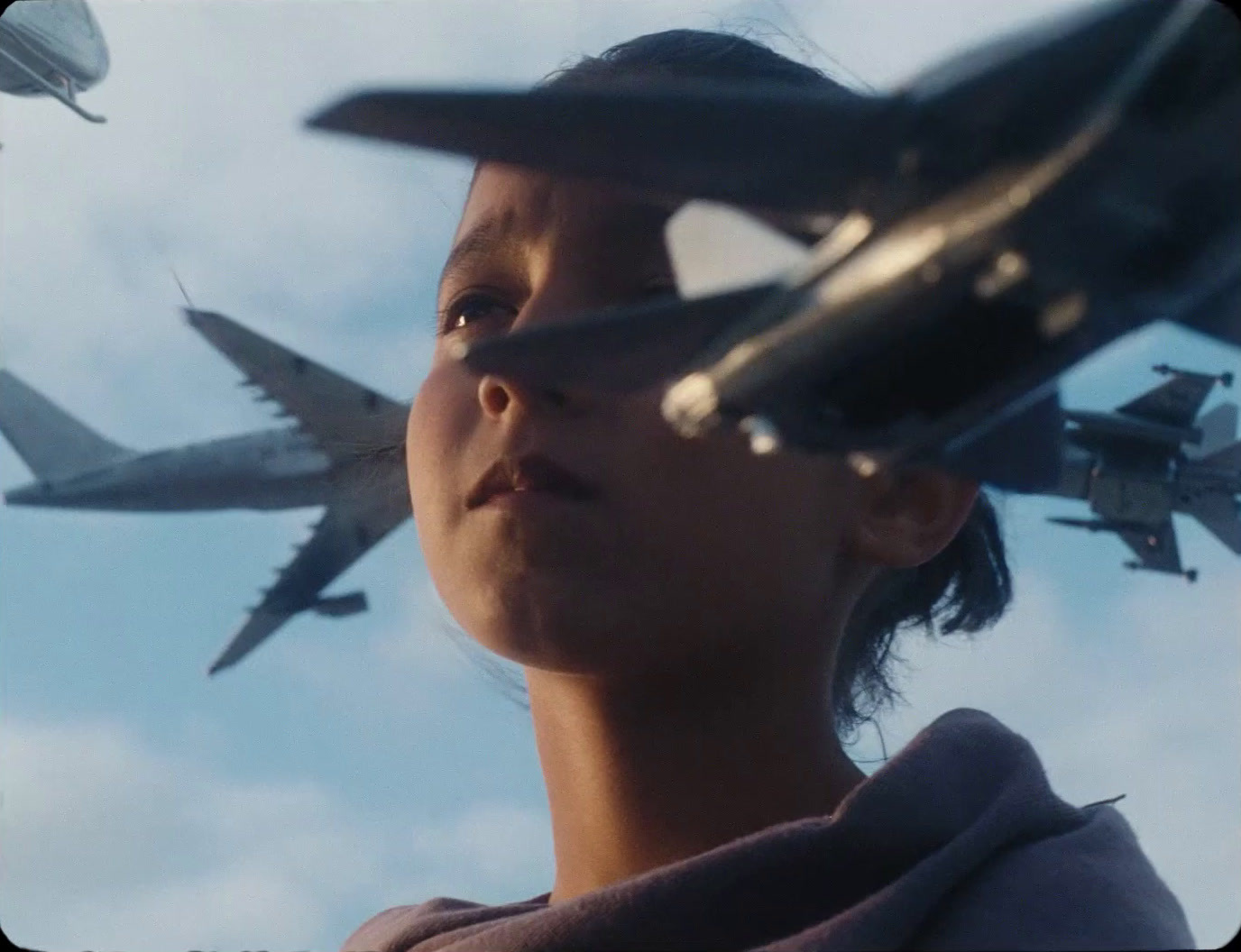 a woman looking up at a bunch of airplanes