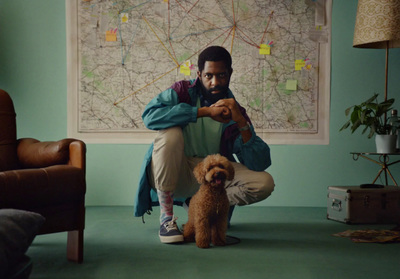 a man kneeling down next to a brown dog