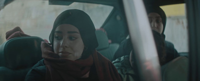 a woman sitting in a car talking on a cell phone