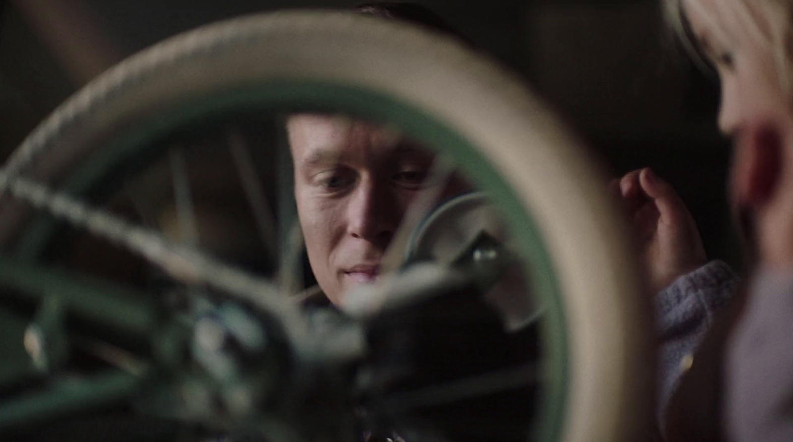 a man looking in a mirror at a bicycle wheel