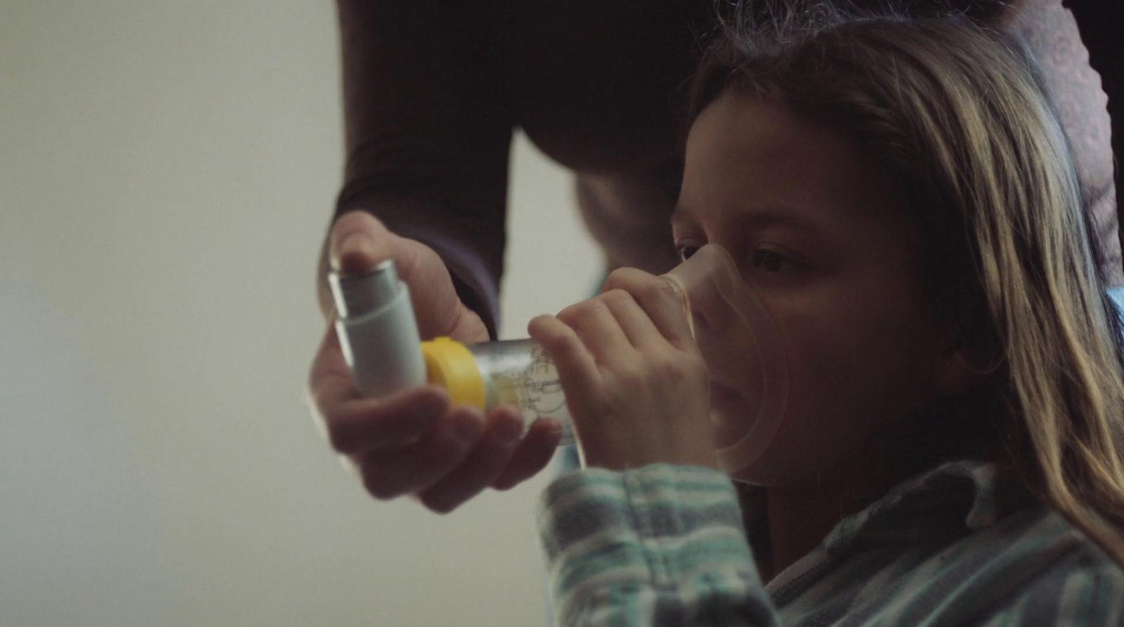 a young girl is drinking from a blender