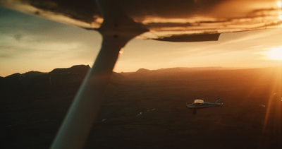 a small airplane flying over a mountain range