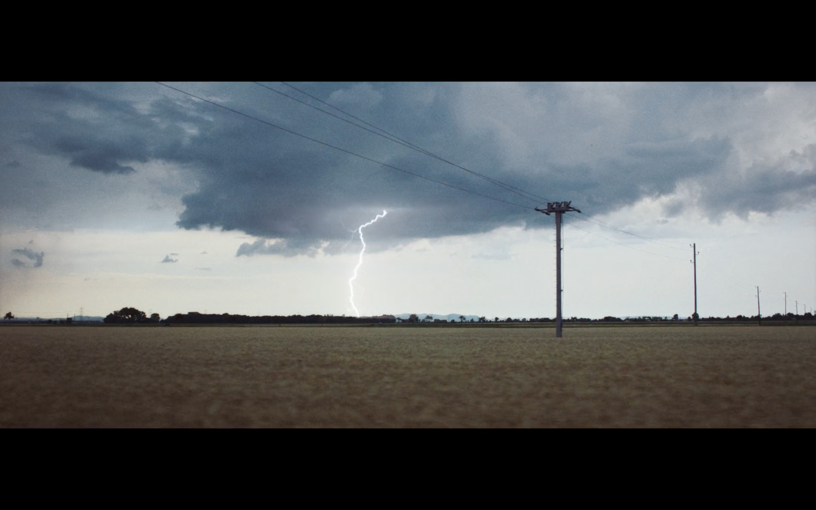 a large field with a telephone pole in the middle of it