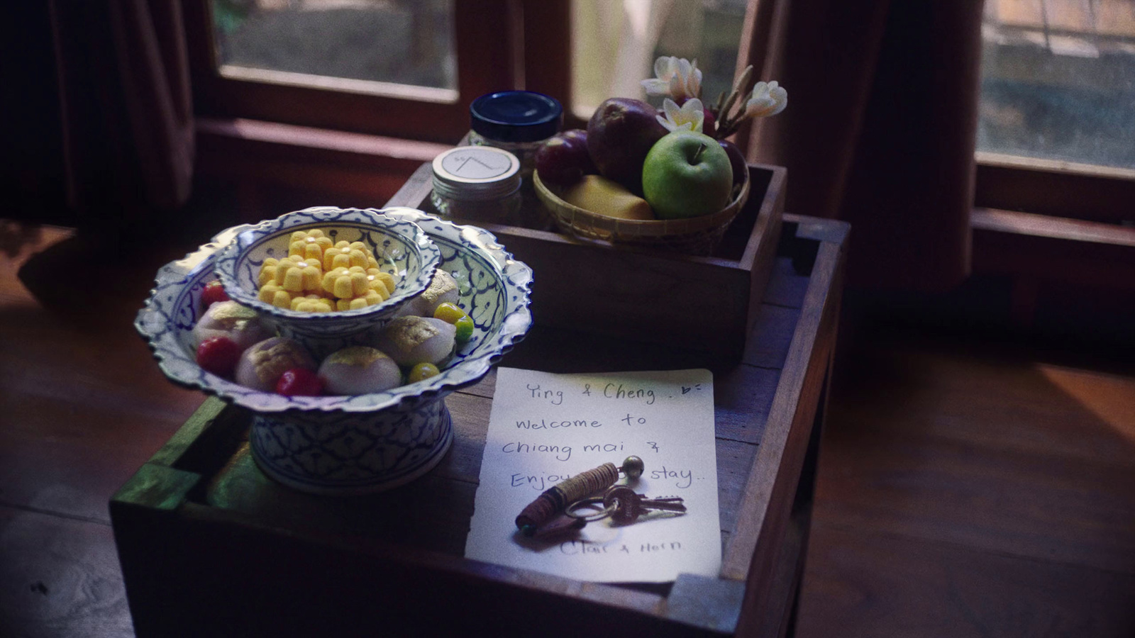 a table with a bowl of fruit and a note on it