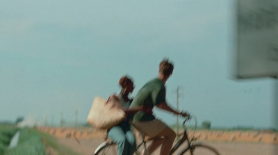 a man and a woman riding a bike down a road