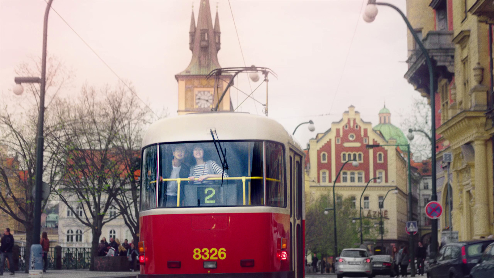 a red and white trolley traveling down a street