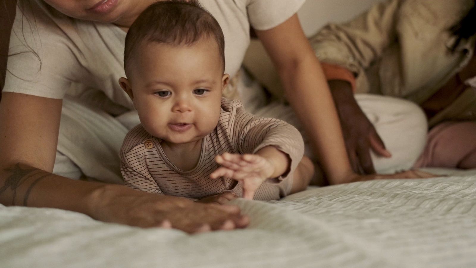 a woman and a baby laying on a bed