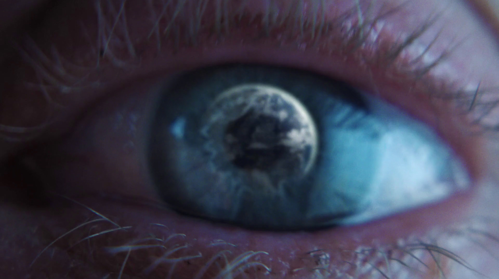 a close up of a person's eye with the reflection of the earth in