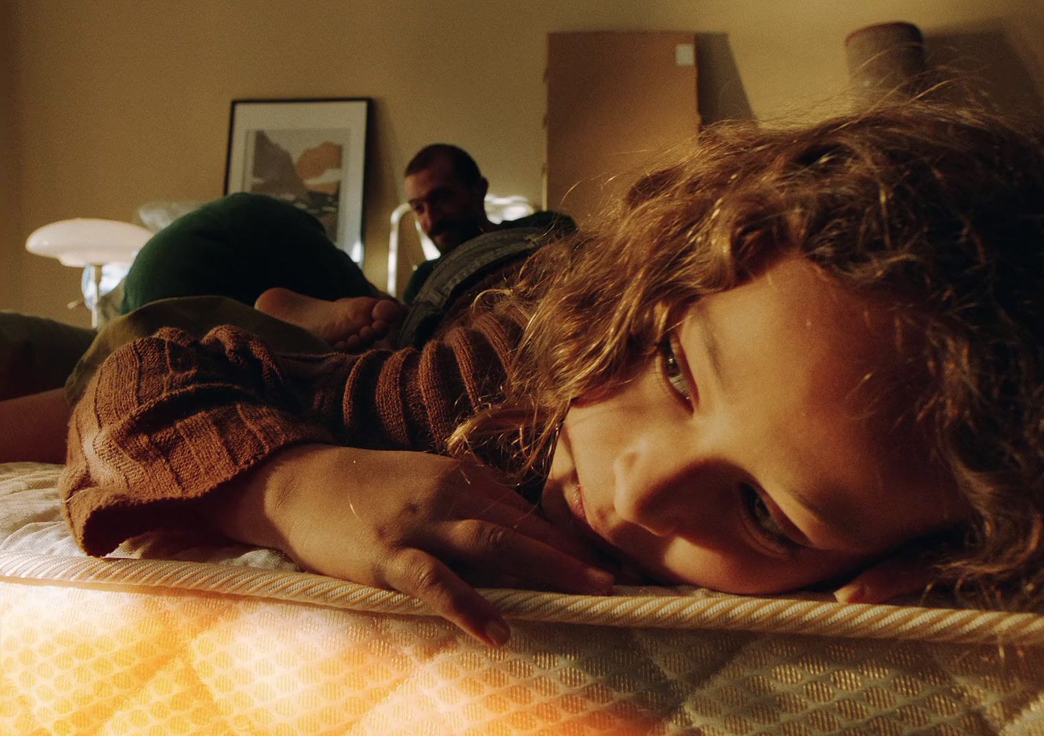 a little girl laying on top of a bed next to a man