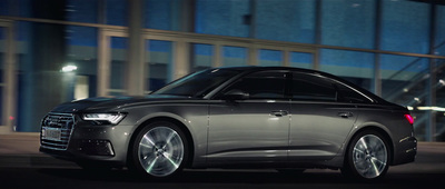 a silver car driving down a street at night