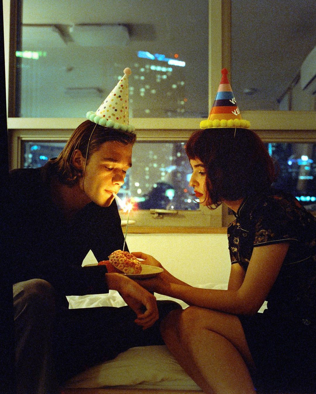 a man and a woman sitting on a window sill