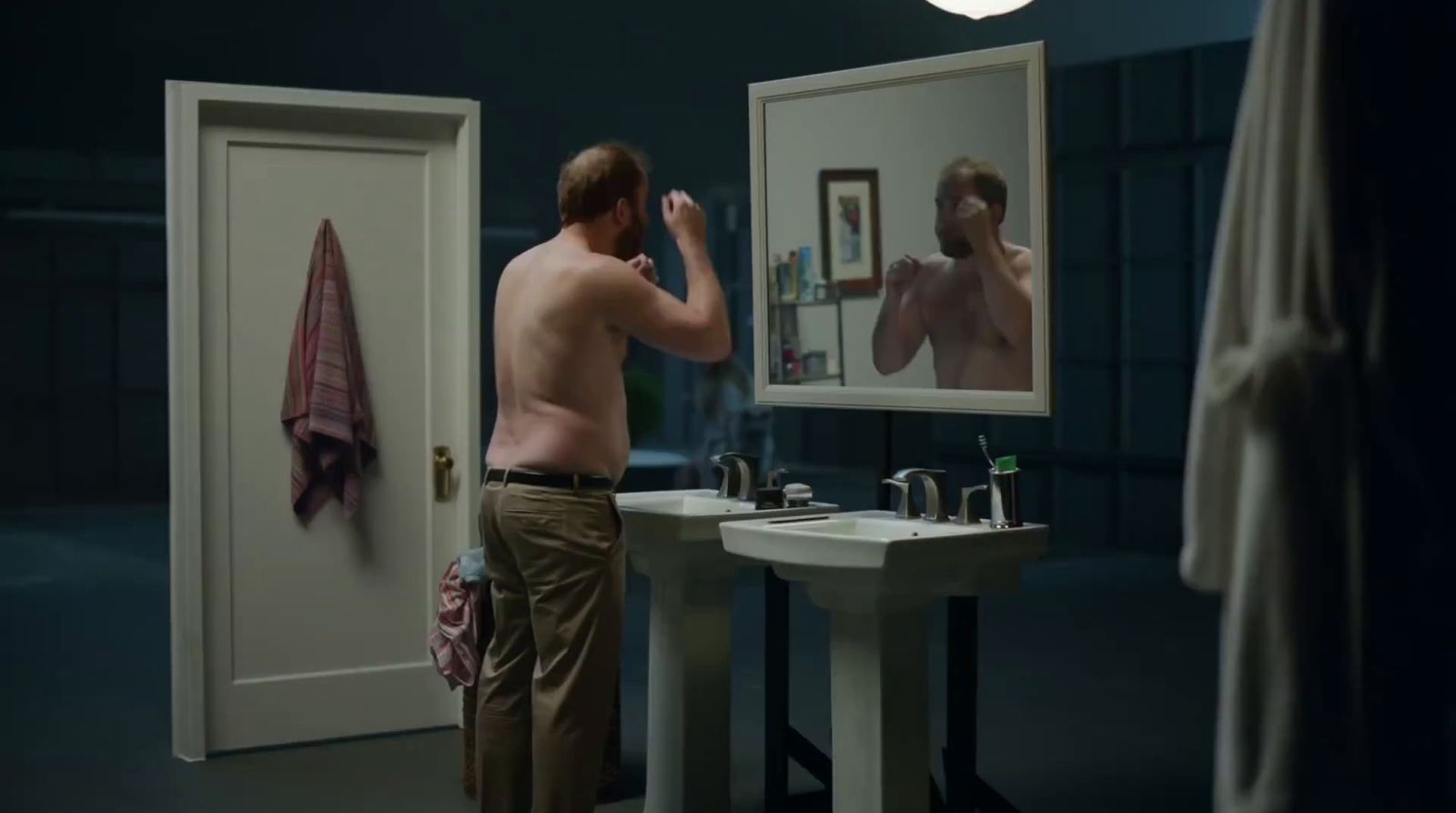 a man standing in front of a mirror brushing his teeth