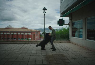 a man is holding a dog on the street