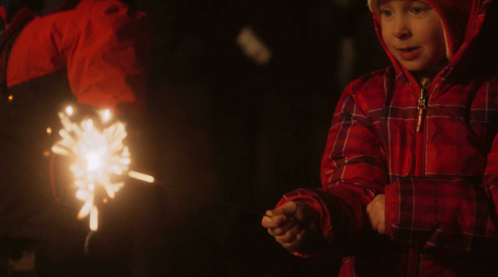 a young boy holding a sparkler in his hand