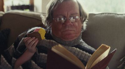 a man sitting on a couch reading a book