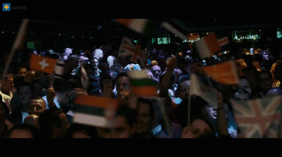 a crowd of people holding flags in the dark