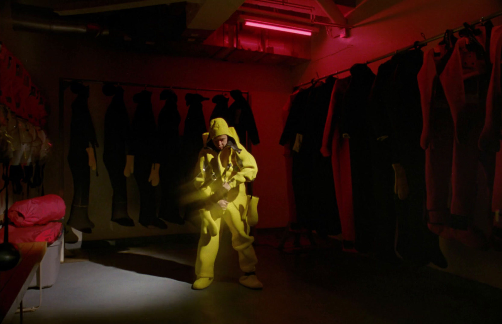 a man in a yellow suit standing in a room