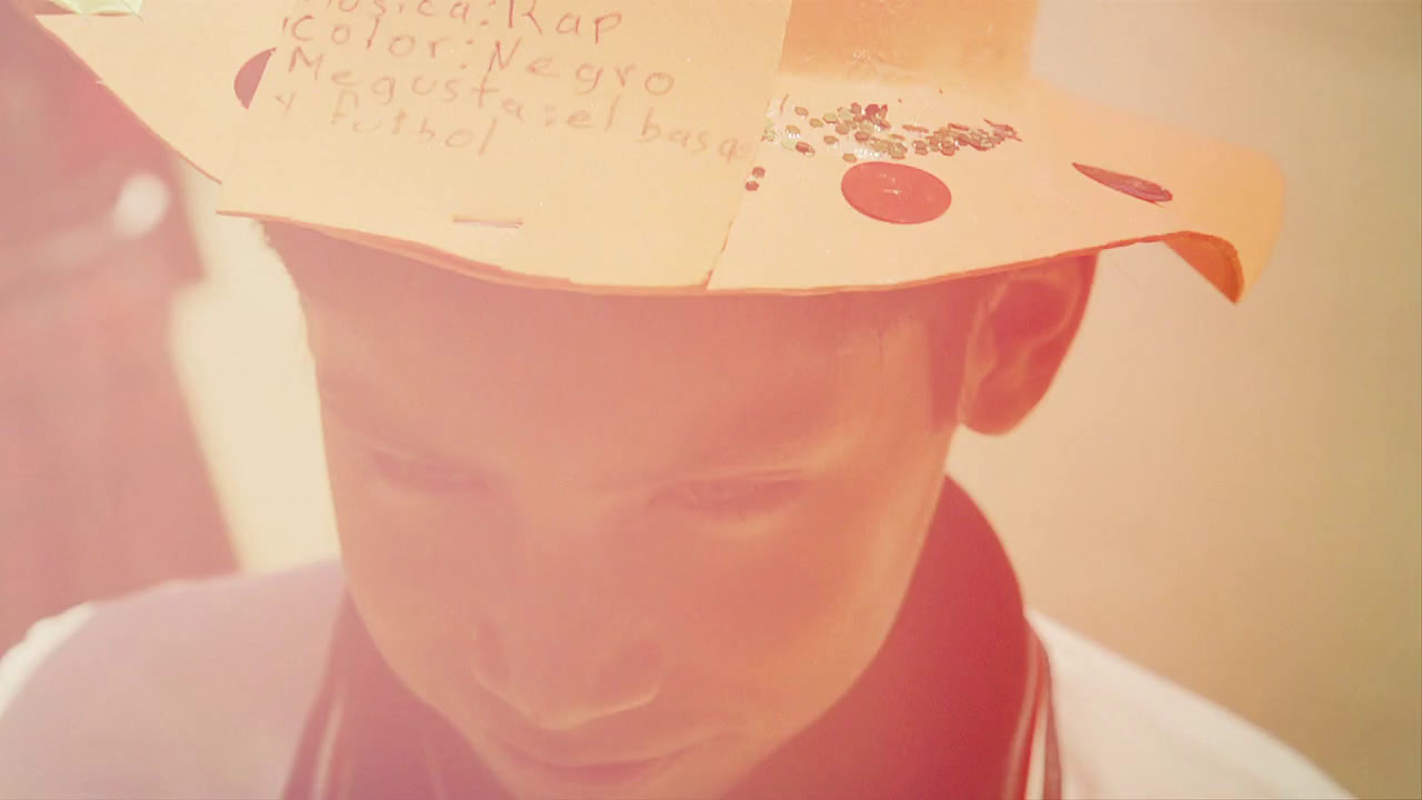 a young man wearing a paper hat with writing on it