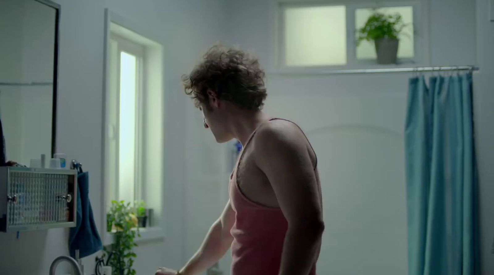 a man standing in a bathroom next to a sink